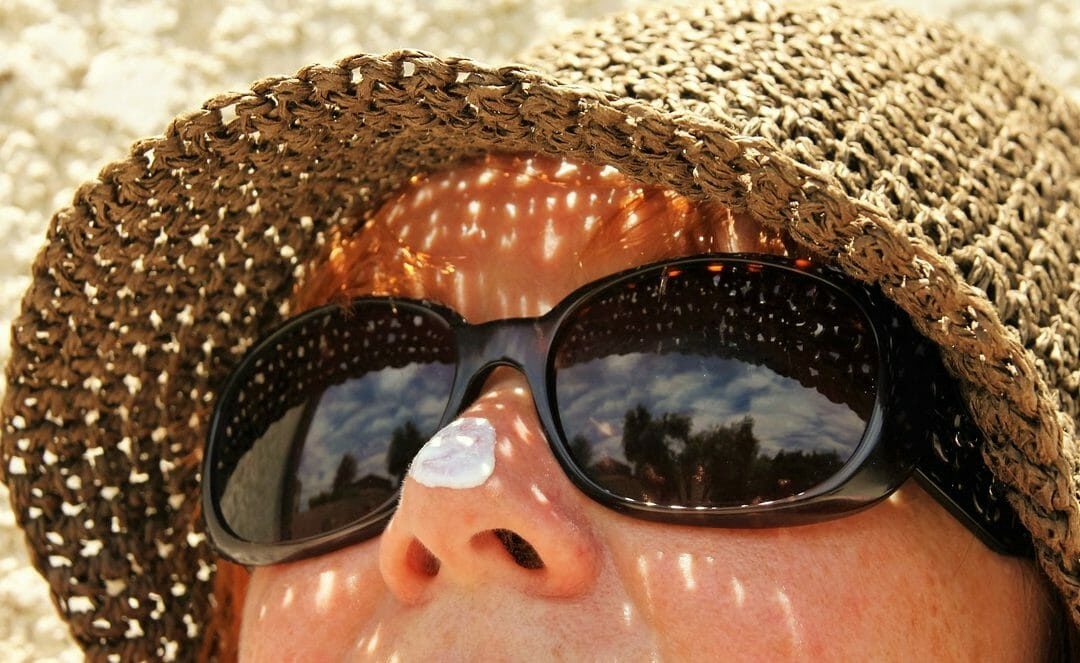 A woman wearing sunblock on her nose